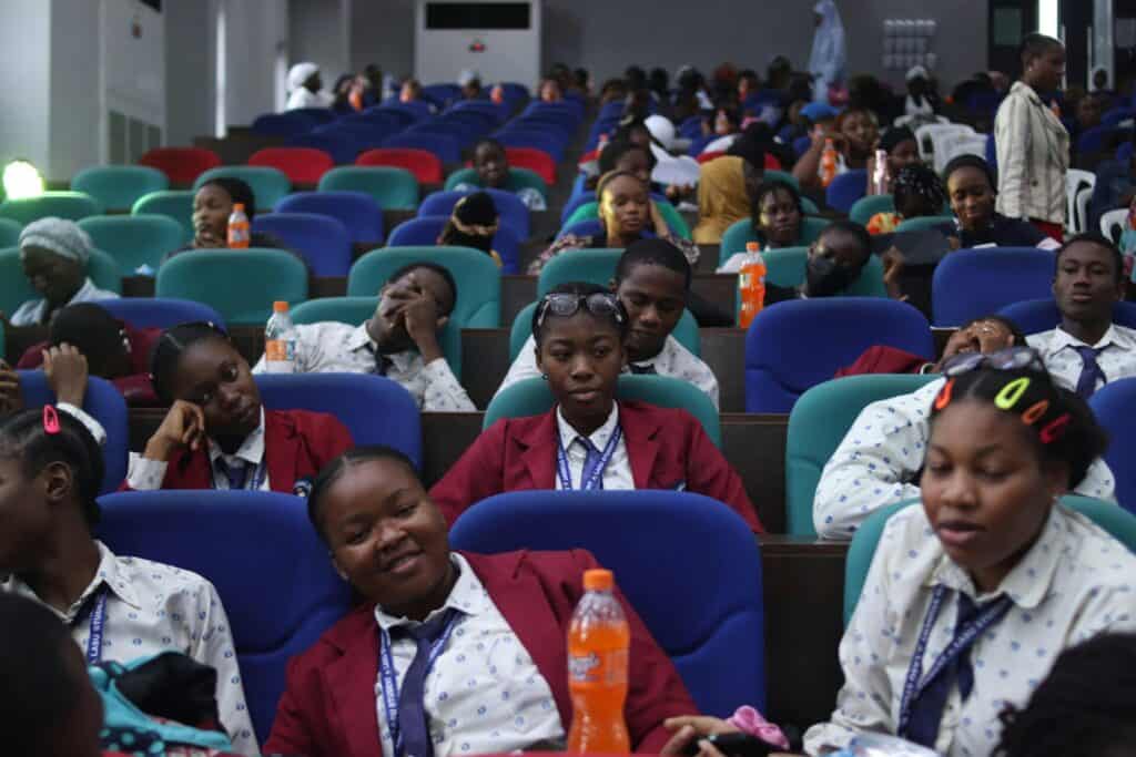 Students attending a lively lecture in a colorful hall in Lagos, Nigeria.